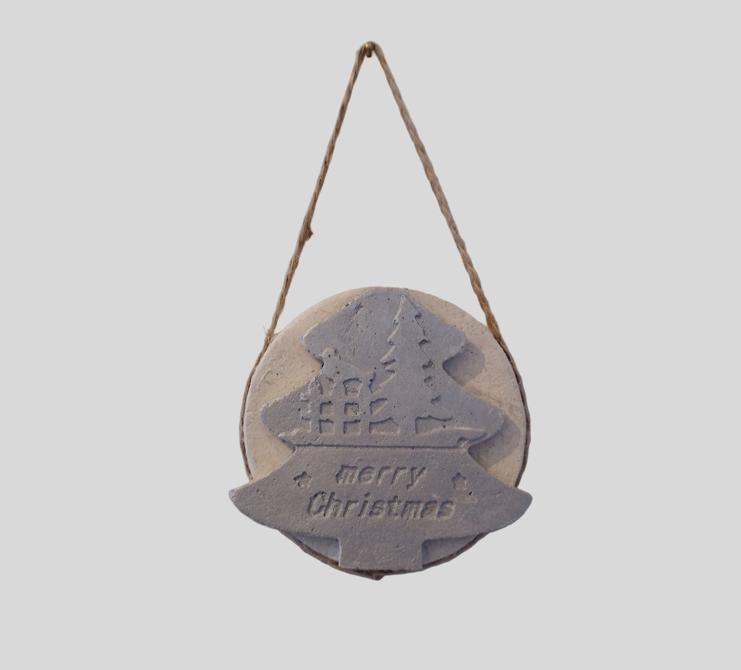 Round hanging Christmas decoration with a tree design and 'Merry Christmas' text on a light gray background.