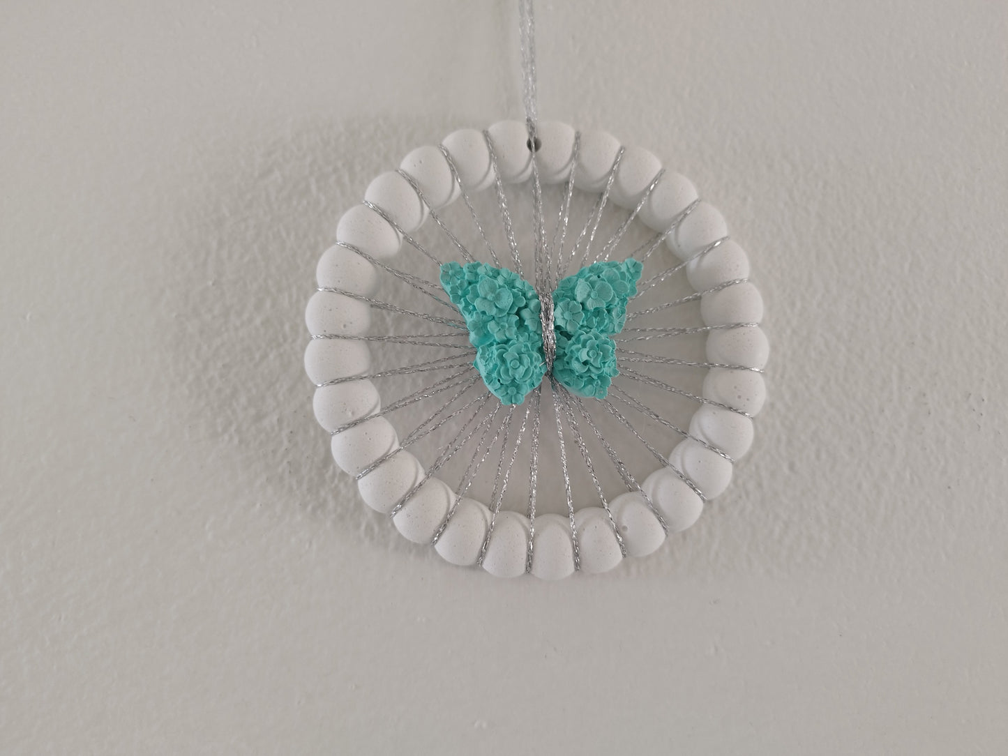 Τσιμεντένια ονειροπαγίδα με τυρκουάζ τσιμεντένια πεταλούδα σε άσπρο φόντο