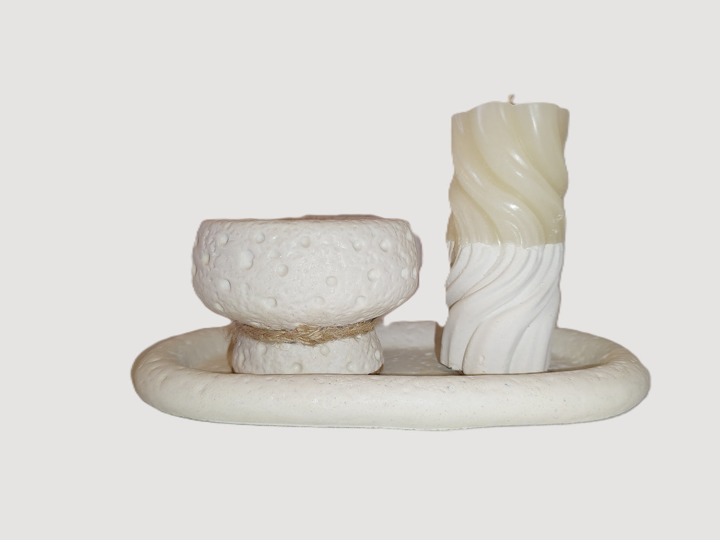 Decorative candle holder with a textured candle on a plain background