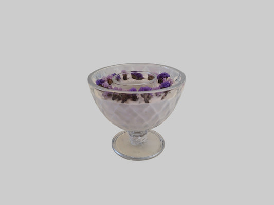 Glass dessert bowl with purple flowers on a light gray background