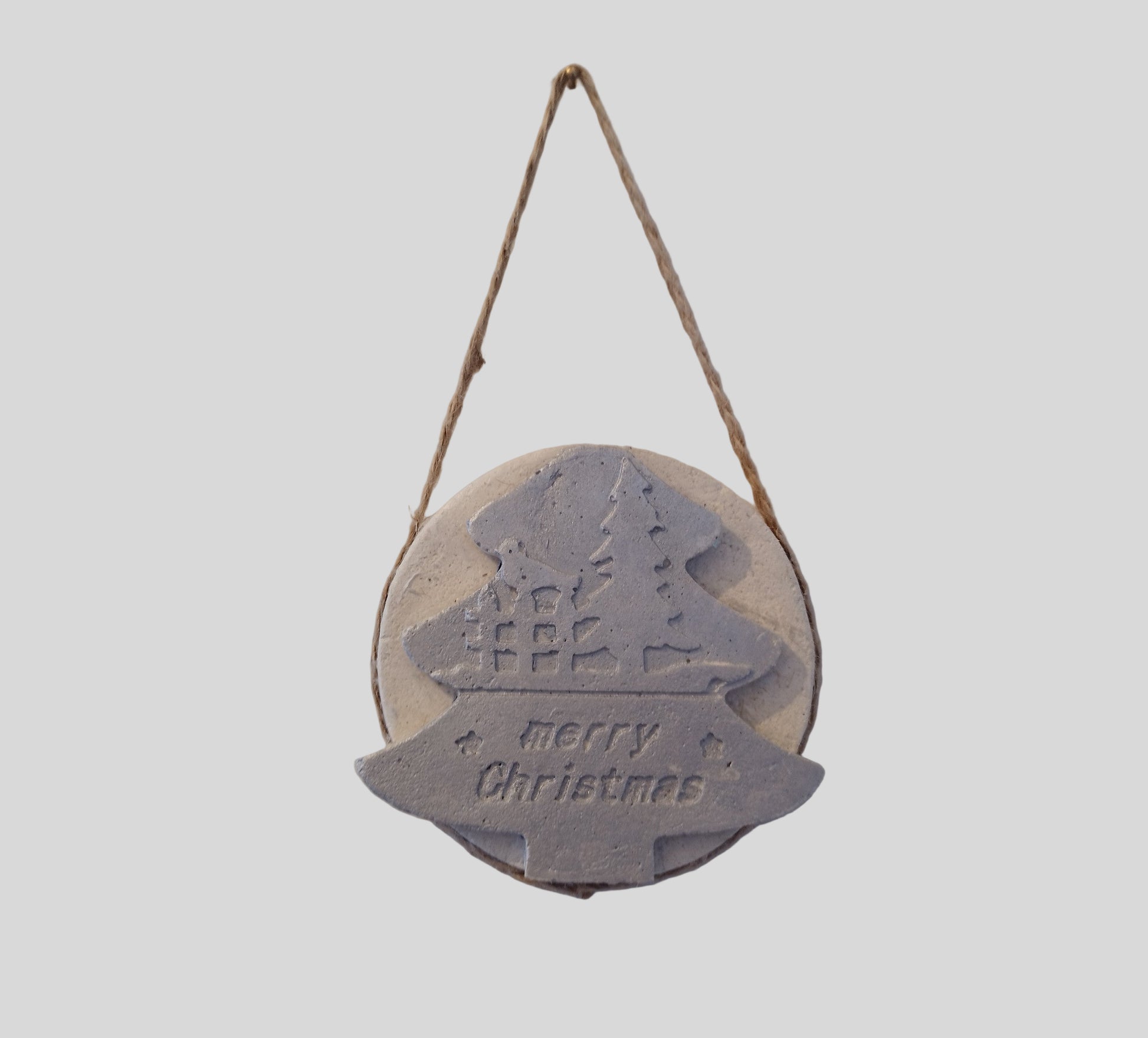 Round hanging Christmas decoration with a tree design and 'Merry Christmas' text on a light gray background.

