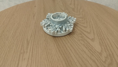 Decorative silver snowflake candle holder on a wooden table in the front