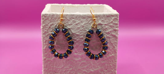 Σκουλαρίκια με μαύρες χάντρες και χρυσά κρικάκια.