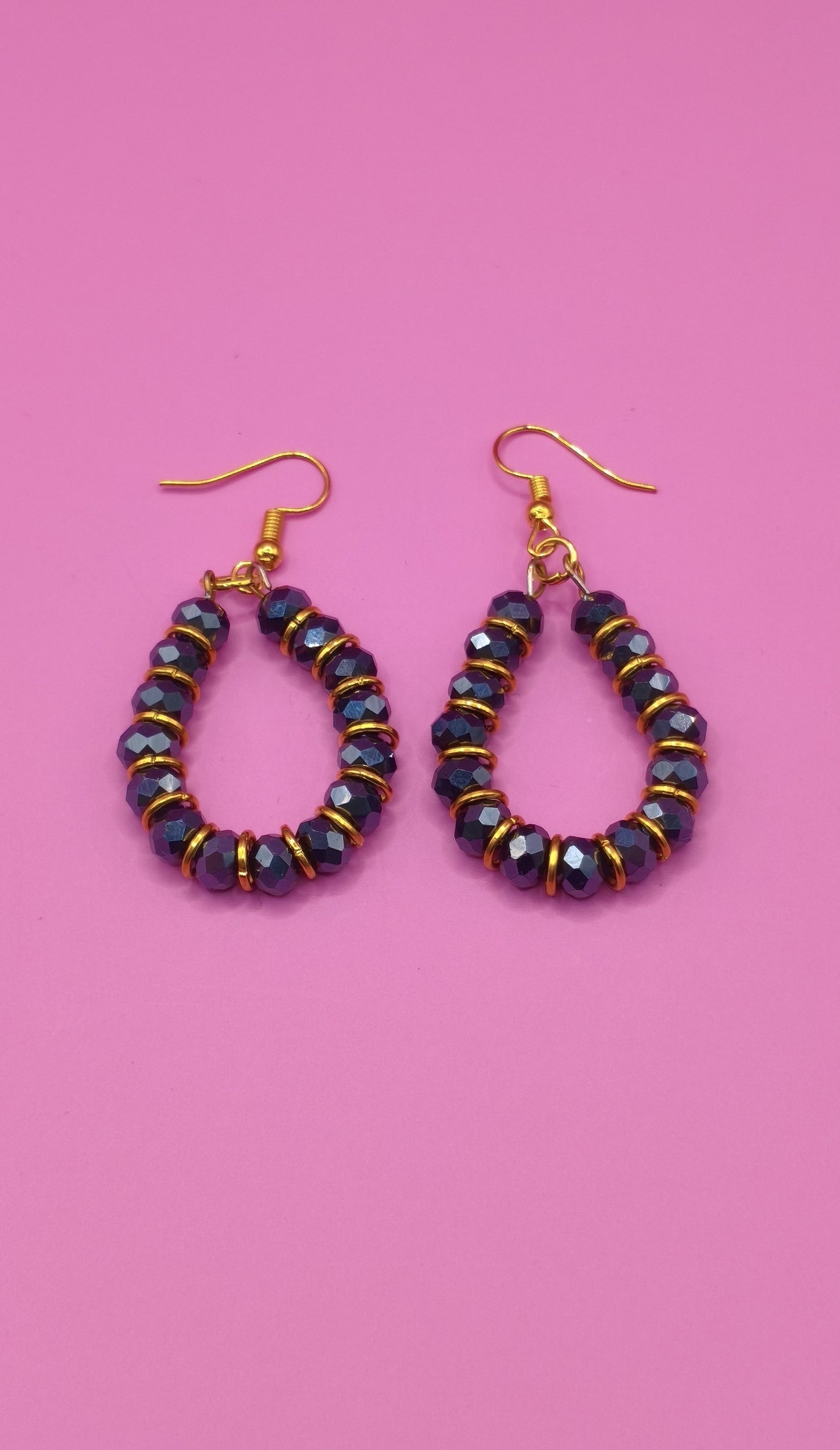 Σκουλαρίκια με μαύρες χάντρες και χρυσά κρικάκια.