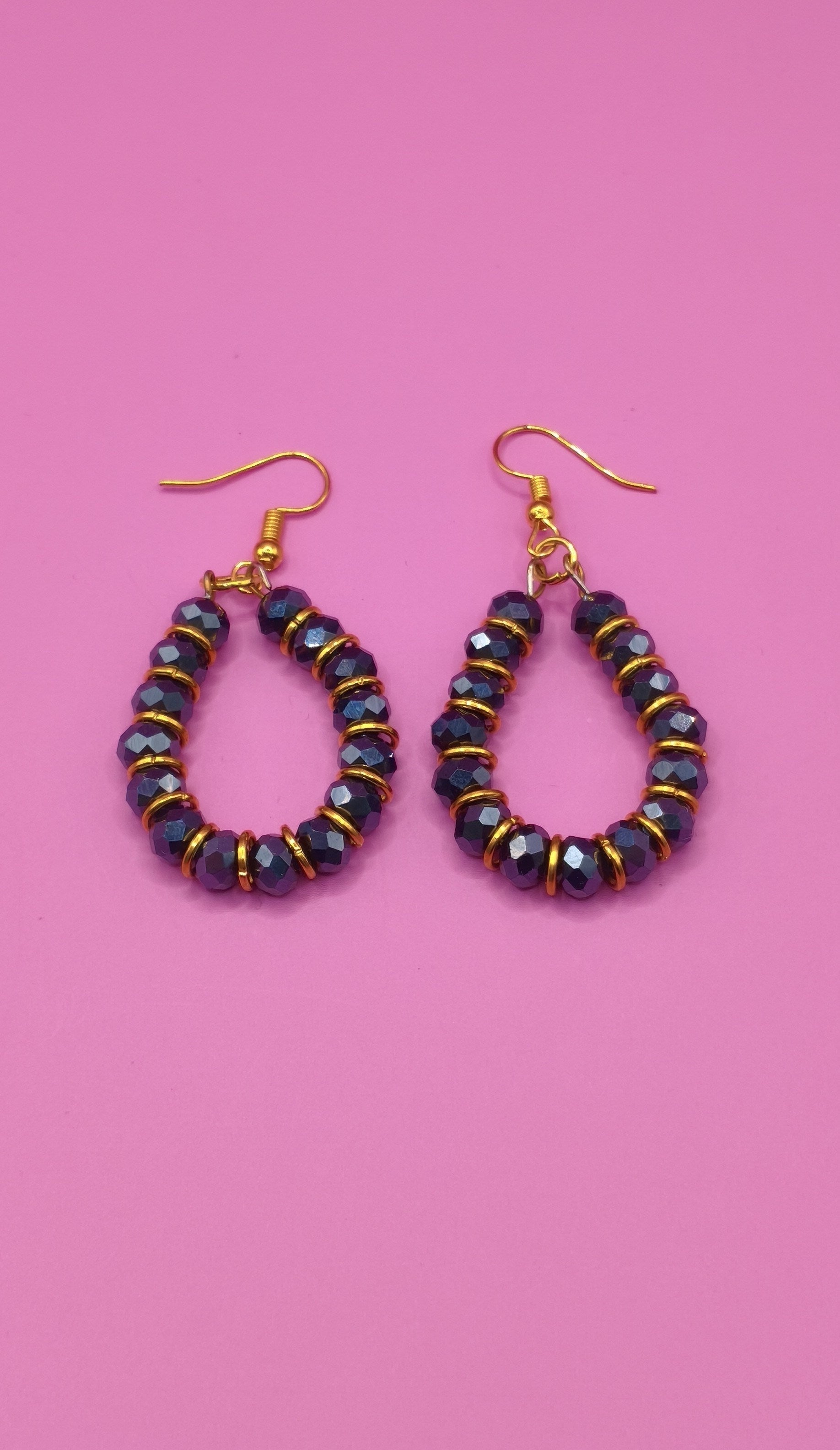 Σκουλαρίκια με μαύρες χάντρες και χρυσά κρικάκια.