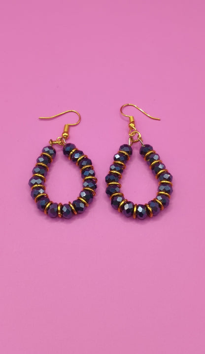 Σκουλαρίκια με μαύρες χάντρες και χρυσά κρικάκια.