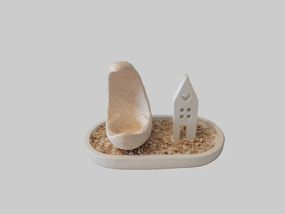 Τσιμεντένιο πιατάκι με ρεσώ και μικρό σπιτάκι από τσιμέντο σε γκρι φόντο