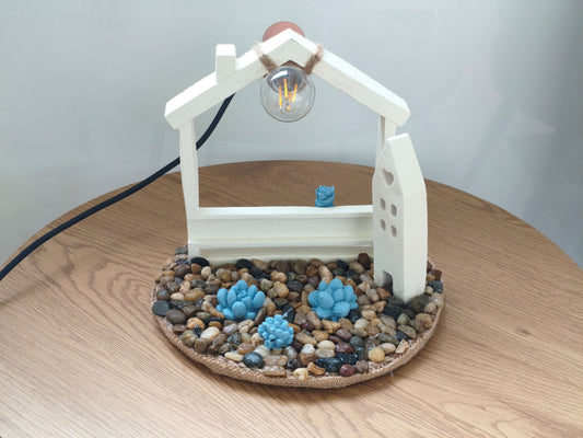 Φωτιστικό με τσιμεντένια σπιτάκια πάνω σε ξύλινο τραπέζι