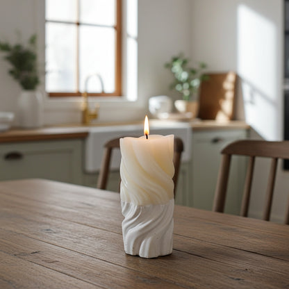 Candle in a cement base on a wooden table with a kitchen in the background
