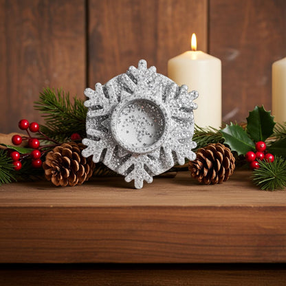 Decorative silver snowflake candle holder on a wooden surface