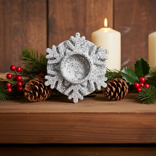 Decorative silver snowflake candle holder on a wooden surface