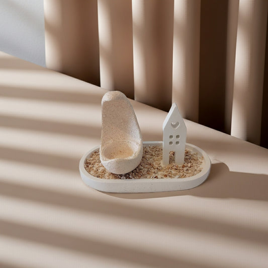 Τσιμεντένιο πιατάκι με ρεσώ και μικρό σπιτάκι από τσιμέντο πάνω σε τραπέζι