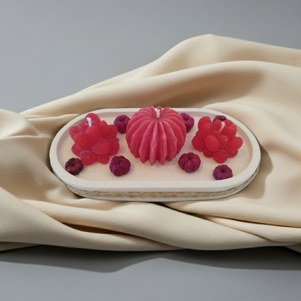 Decorative candle with raspberry design on a beige fabric background