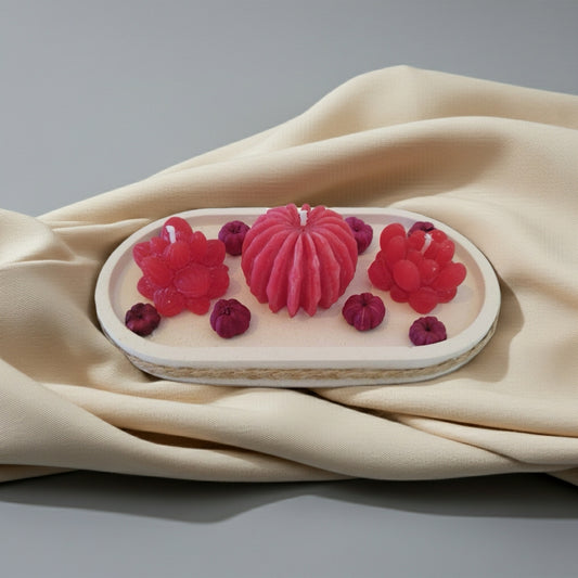 Decorative candle with raspberry design on a beige fabric background