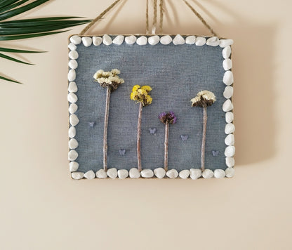 Διακοσμητικό καδράκι από φελλό με αποξηραμένα λουλούδια κρεμασμένο σε τοίχο