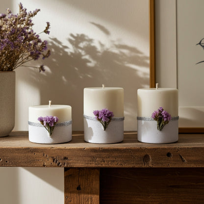 Σετ τριών λευκών κεριών με τσιμεντένια βάση πάνω σε ξύλινο τραπέζι