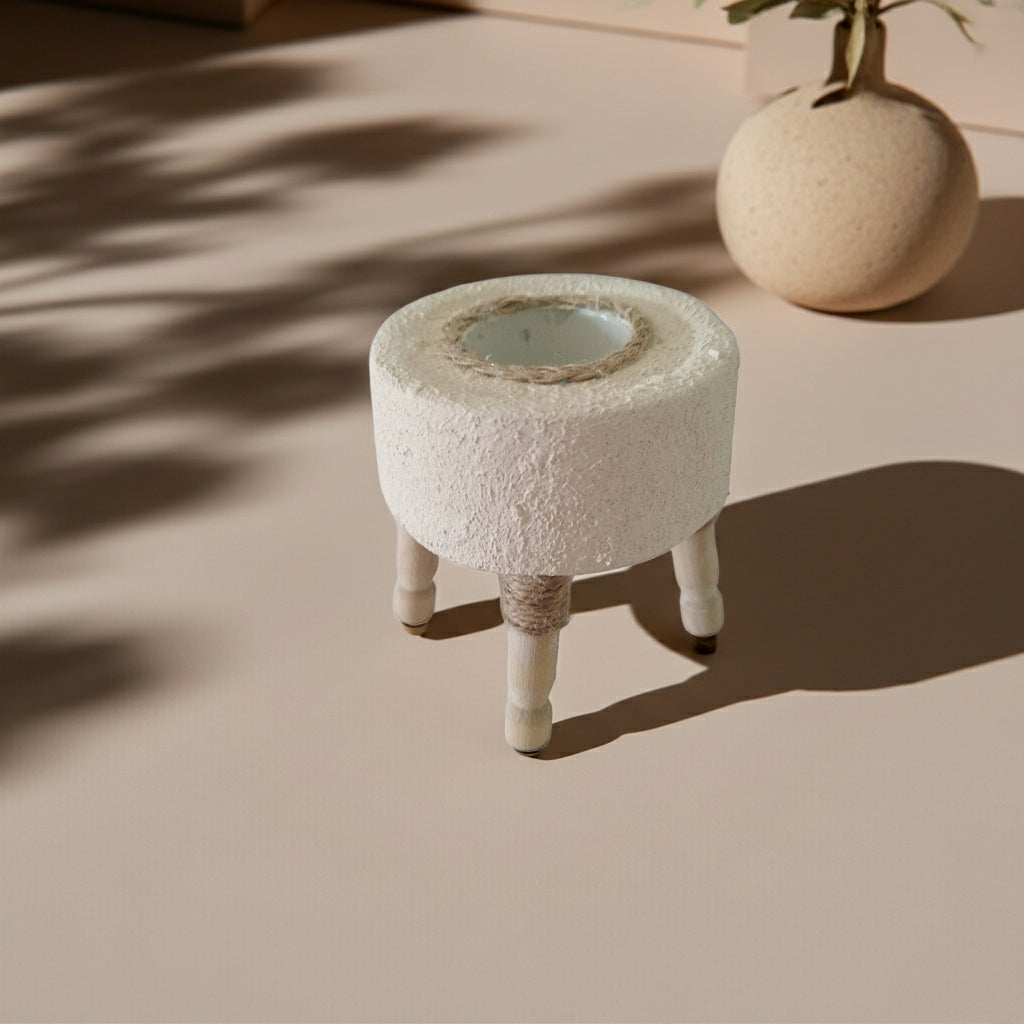 Στρογγυλό τσιμεντένιο ρεσώ με ανάγλυφη υφή και ξύλινα ποδαράκια πάνω σε τραπέζι