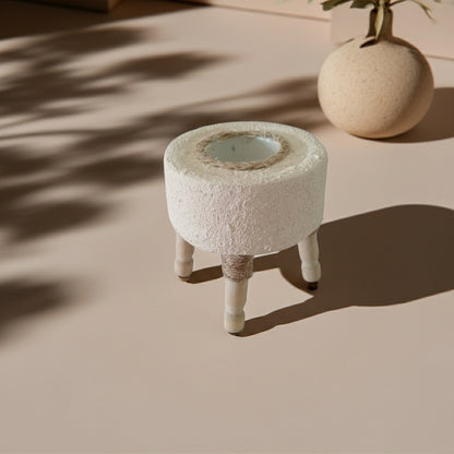 Στρογγυλό τσιμεντένιο ρεσώ με ανάγλυφη υφή και ξύλινα ποδαράκια πάνω σε τραπέζι